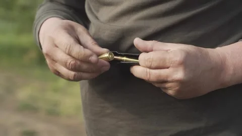 Use your hands to charge the rifle magazine with cartridges Stock Footage 245918662