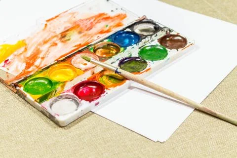 Used box with multi-colored paints and a brush for painting. Diagonally Stock Photos