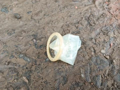 Used condom on the ground Stock Photos