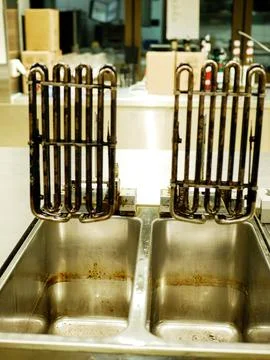 Used deep fryer heating elements and vats on restaurant kitchen counter Stock Photos