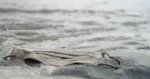 Used disposable face mask on the sandy beach, Ecological pollution problem Stock Footage 157626693