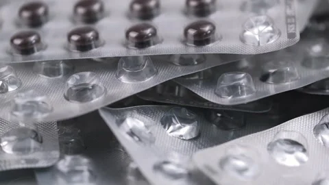 Used empty blisters from tablets and last tablets slowly rotate. close up. Stock Footage 247610323