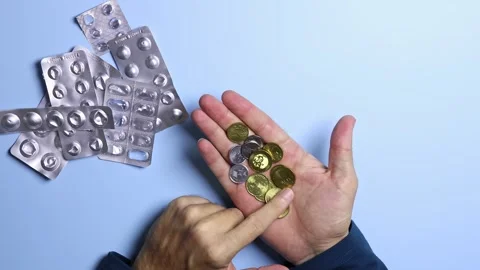 Used empty pill blisters and man's hands counting Malaysian ringgit (MYR) coins. Stock Footage 303342155