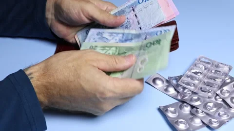 Used empty pill blisters and man's hands counting Thai baht (THB) banknotes. Stock Footage 303365916
