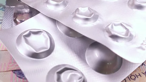 Used empty pill blisters over new sample of five hundred vietnamese dong bills. Stock Footage 294594733
