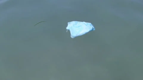 Used face mask floating on contaminated sea surface,covid19 nature pollution Stock Footage 157869020
