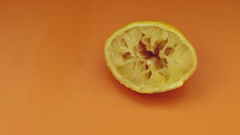 Used lemon on orange background Stock Footage 80350906