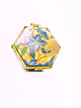 A used luxurious small ceramic box with golden trim and flowral pattern isola Stock Photos