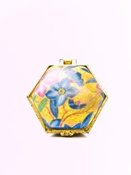 A used luxurious small ceramic box with golden trim and flowral pattern isola Stock Photos