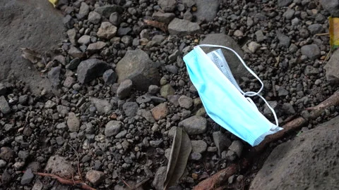 Used mask left on the ground which is a recent environmental issue Stock Footage 148456682
