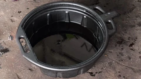 Used motor oil draining into a black pan Stock Footage 346410997