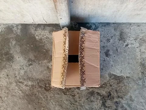 Used Open Cardboard Box with Patterned Tape on Concrete Stock Photos