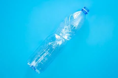 Used plastic bottle on a blue background, top view, flat lay. Stock Photos