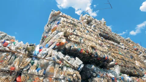 Used plastic bottles storaged in pressed blocks outdoors ready for recycling Stock Footage