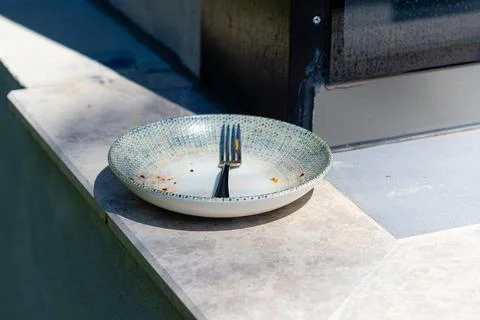 Used Plate with Fork on Stone Ledge Stock Photos