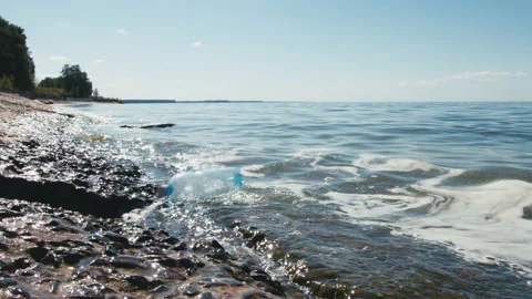 Used polyethylene bottle is brought to seashore by tide waves Stock Footage 207502931