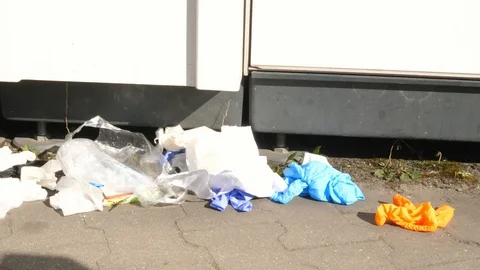 Used protection gloves plastic garbage rubbish lying on street sunny bright day Stock Footage 129100536