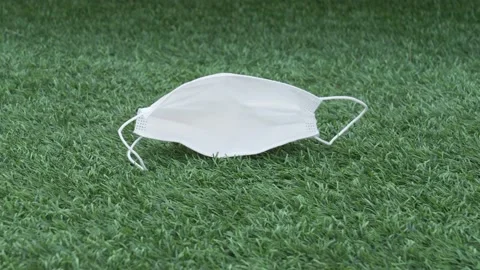 Used protective face mask on the ground. Discarded trash medical face mask Stock Footage 131551841