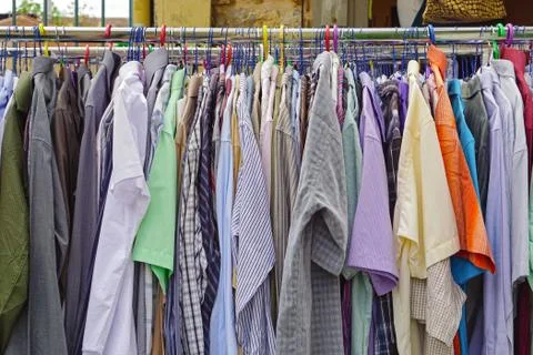 Used shirts hanging at clothes rails Stock Photos