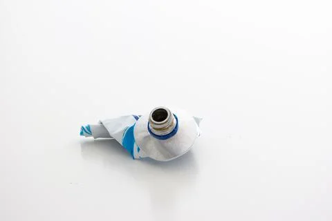 Used up squeezed out metal paste tube ready for recycling close up studio sho 库存照片