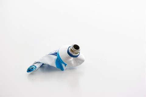 Used up squeezed out metal paste tube ready for recycling close up studio sho 库存照片