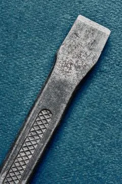 Used stone chisel on blue background, macro, top view Stock Photos