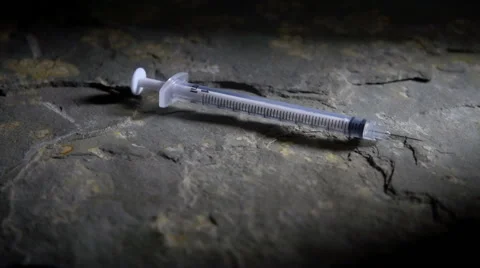 Used syringe falling in slow motion Stock Footage 55707411
