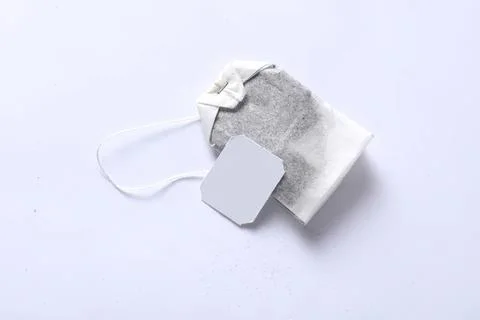Used tea bag with string and paper tag on white background Stock Photos