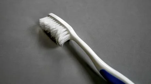 Used Toothbrush on Gray Background Foto stock