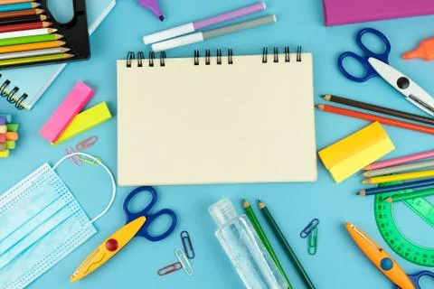 Useful for the return to school with mask and disinfectant gel on a blue back Stock Photos