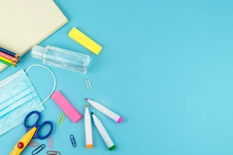 Useful for the return to school with mask and disinfectant gel on a blue back Stock Photos