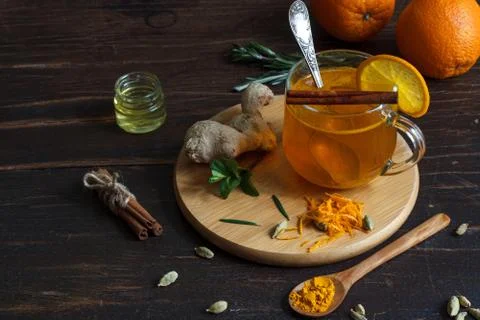 Useful tea with saffron and ginger in a glass mug on a dark wooden background Stock Photos