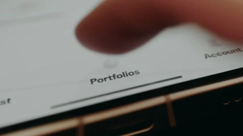 User accesses the Portfolios navigation option within a financial app Video stock 330249740