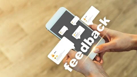 User checks feedback on a mobile phone in a well-lit area with a wooden floor Stock Photos