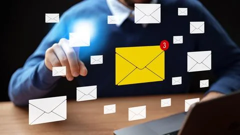 User checks new messages on a computer with mail icons floating around at night Stock Photos