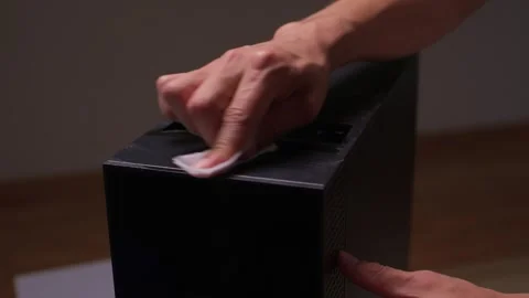 A user cleans a computer case with a soft cloth, ensuring its cleanliness and Stock Footage 312529358
