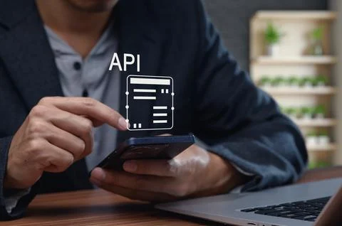 User Engaging with API Interface on Smartphone and Laptop Stock Photos