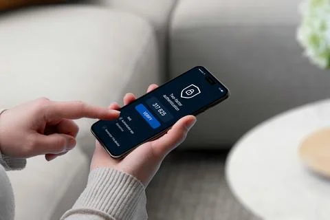 User entering 2FA code on smartphone screen with security shield icon, repr.. Stock Photos