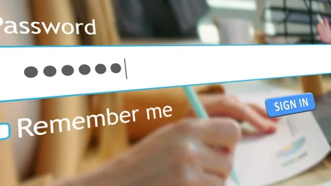 User enters password in browser on office desk with employees present Stock Footage 334022445