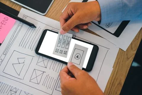 User experience UX designer designing web on smart phone layout. UI developer Stock Photos