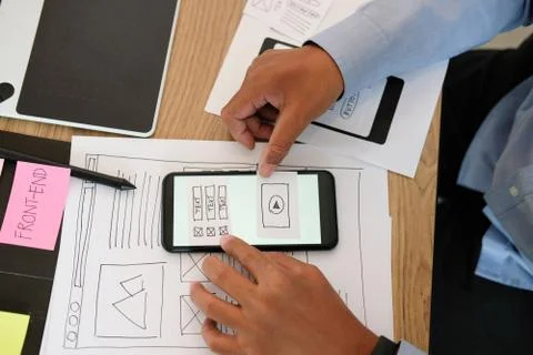 User experience UX designer designing web on smart phone layout. UI developer Stock Photos