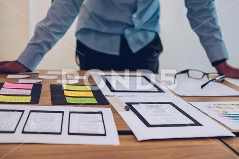 User experience UX designer designing web on smart phone layout. UI developer Stock Photos