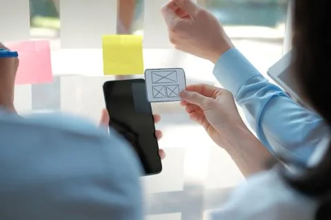 User experience UX designer designing web on smart phone layout. UI developer Stock Photos