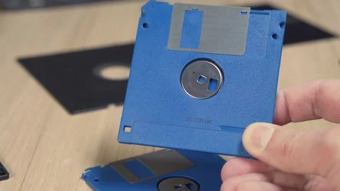 User is holding a blue floppy disk. Obsolete computer technology. Video stock 149424183