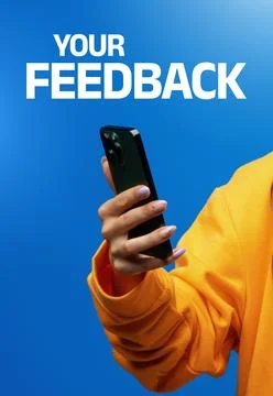 User holds smartphone while engaging with the message about feedback on blue Stock Photos