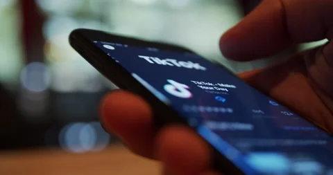 User installint TikTok video-sharing social networking app on a smartphone devic Stock Footage 136956359