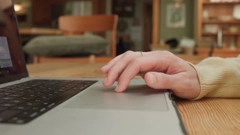 User Interacts with Laptop Touchpad in Relaxed Home Environment Stock Footage 320588760