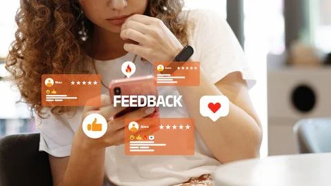 User interacts with mobile device while reviewing feedback at a cafe Stock Photos
