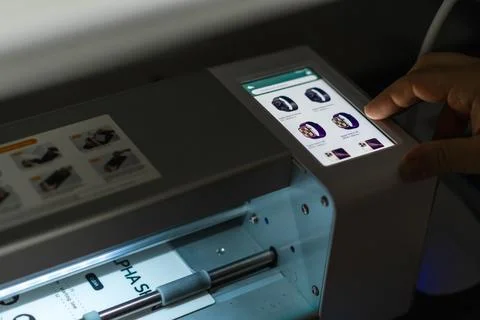 User interacts with a precise plotter for cutting hydrogel film in a modern.. Stock Photos