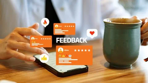 User interacts with a smartphone and coffee while viewing feedback on a wooden Stock Photos